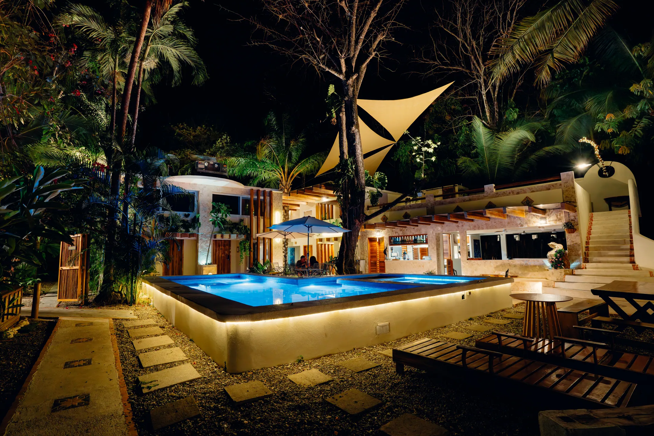 Piscina y arquitectura tropical de Dreamcatcher por la noche